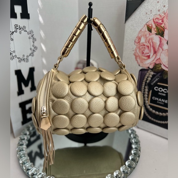 unique design with embossed circular details and a structured, metallic handle. - Picture 1 of 12